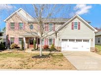 Charming two-story home boasts a brick facade, two-car garage, and a well-manicured front yard at 5020 Clover Hill Rd # 61, Indian Trail, NC 28079