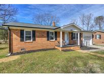 Charming brick home features a cozy front porch and well-maintained landscaping at 664 Westside Ter, Davidson, NC 28036