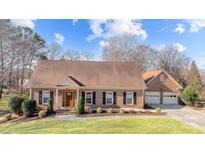 Charming brick home featuring a well-manicured lawn, dark shutters, and an attached two-car garage at 7916 Wellston Dr, Charlotte, NC 28210