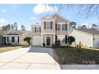 Charming two-story home with a well-maintained lawn, inviting front porch and convenient driveway at 10337 Hugue Way, Charlotte, NC 28214