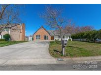 Charming single-story home with brick accents, lush lawn, and a welcoming front porch at 12012 Stainsby Ln, Charlotte, NC 28273