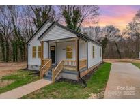 Charming remodeled single-story home featuring a cozy porch and black trim on a professionally landscaped lot at 1207 Patterson St, Shelby, NC 28152