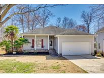 Charming single-story home with a well-manicured lawn, attached garage, and inviting front porch at 125 Rocky Trail Ct, Fort Mill, SC 29715