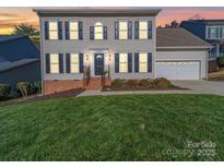 Charming two-story home featuring a well-manicured lawn and attached garage at 12642 Cardinal Woods Dr, Pineville, NC 28134