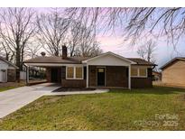 Charming brick home featuring a carport and well-maintained lawn at 209 Palmer St, Shelby, NC 28150