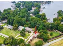 Lush landscaping surrounds this lakeside home featuring a charming roofline and an inviting front entrance at 21114 Bethel Church Rd, Cornelius, NC 28031