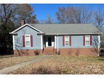 Charming single-story home featuring red shutters, a brick foundation, and a welcoming front entrance at 2234 Oak Leigh Dr, Charlotte, NC 28262