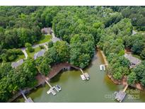 Expansive aerial view of waterfront homes featuring private docks surrounded by lush greenery and lake access at 228 Wildwood Cove Dr, Mooresville, NC 28117