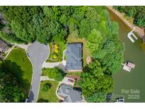 Stunning aerial view of lakefront property, lush trees, and boat dock offer an idyllic retreat at 228 Wildwood Cove Dr, Mooresville, NC 28117