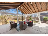 Inviting covered patio with comfortable seating and stunning lake views, perfect for outdoor relaxation and entertaining at 228 Wildwood Cove Dr, Mooresville, NC 28117