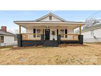 Charming home featuring a covered front porch, classic black shutters, and a well-maintained yard at 612 Miller St, Kannapolis, NC 28081