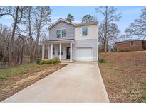Charming two-story home with neutral siding and an attached garage on a slightly wooded lot at 613 N Pink St, Cherryville, NC 28021