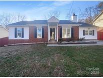 Charming single-story home with a brick facade, white siding, dark shutters, and a well-maintained front yard at 6440 Tivoli Ct, Charlotte, NC 28211