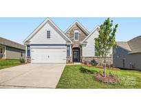 Charming home featuring a two-car garage, stone accents, well-maintained lawn, and inviting curb appeal at 8422 Norman Forest Rd, Lancaster, SC 29720