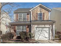 Charming two-story home featuring a blend of brick and shingle siding, with a two-car garage and well-maintained landscaping at 9566 Turning Wheel Dr, Charlotte, NC 28214