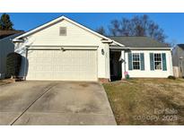 Charming one-story home featuring a two-car garage, white siding, blue shutters, and a well-manicured lawn at 1007 Bitter Root Ct, Monroe, NC 28110