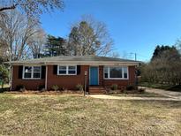 Charming brick home featuring a well-manicured lawn, blue front door, and inviting curb appeal at 1116 Peachtree Rd, Charlotte, NC 28216