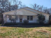 Classic single story home featuring a covered front porch and traditional siding, set against a backdrop of mature trees at 1222 Sparrow Springs Rd, Kings Mountain, NC 28086