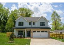 Charming two-story home with a light blue exterior, a brick-accented garage, and a well-manicured front yard at 13110 Blacksmith Ct, Matthews, NC 28105