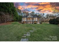 Expansive backyard with a stone path leading up to a home with a covered porch, perfect for outdoor living at 15015 Nc Hwy 73 Hwy, Huntersville, NC 28078
