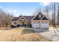 Charming ranch-style home featuring a two-car garage, covered porch, and well-manicured landscaping at 153 Byers Rd, Troutman, NC 28166