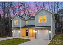 Charming townhome exterior featuring stone accents, single car garages and a well-manicured lawn at 2117 Gemway Dr, Charlotte, NC 28216