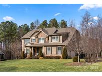 Charming two-story home featuring stone accents, manicured lawn, and mature trees at 3019 Foggy Hollow Ln, Clover, SC 29710