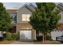 Charming townhome with a brick and siding facade, one-car garage and mature trees at 3306 Yarmouth Ln, Gastonia, NC 28056