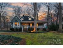 Charming home with a welcoming front porch and manicured lawn at sunset at 402 Belwood Dr, Belmont, NC 28102