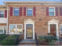 Charming brick townhome exterior featuring classic red shutters and well-maintained landscaping at 6436 Old Pineville Rd # C, Charlotte, NC 28217