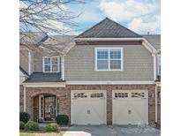 Charming townhome featuring a brick facade, a welcoming entrance, and a two-car garage with carriage-style doors at 8513 Loxton Cir, Charlotte, NC 28214