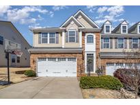 Charming townhome with stone accents, a two-car garage, and a well-maintained lawn in a desirable neighborhood at 121 Inlet Point Dr, Tega Cay, SC 29708