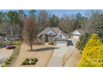 An aerial view of a beautiful brick home with a long driveway and well-manicured yard at 143 Shoreview Dr # 7, Mooresville, NC 28117
