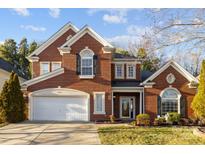 Traditional two-story brick home with well-manicured lawn and attached two-car garage at 15323 Prescott Hill Ave, Charlotte, NC 28277