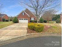 Charming brick home with a two-car garage and well-manicured landscaping at 2702 Occaneechi Ct, Waxhaw, NC 28173