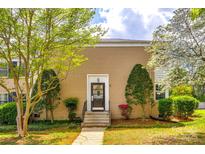 Charming tan brick townhome features a welcoming front door and beautiful landscaping at 315 Wakefield Dr, Charlotte, NC 28209