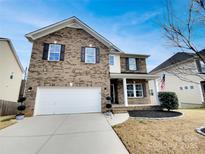 Charming two-story brick home featuring a two-car garage and well-manicured front yard at 6148 Durango Way, Denver, NC 28037