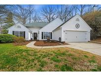 Charming white home with a two-car garage, manicured lawn, and mature trees at 108 Pebble Creek Xing, Fort Mill, SC 29715