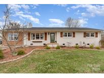 Charming single-story home with white painted brick, dark shutters, and a well-manicured front lawn at 127 Wright Cir, Cherryville, NC 28021