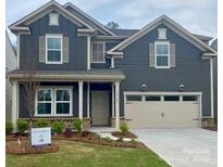 Charming two-story home with gray siding, manicured lawn, and a two-car garage at 13744 Roderick Dr # 173, Huntersville, NC 28078