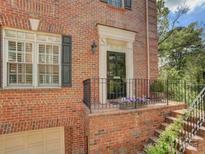 Charming brick home with a black front door, white trim, black shutters, and a landscaped entrance at 352 S Laurel Ave, Charlotte, NC 28207