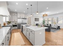 Bright living room with open concept kitchen, fireplace, and hardwood floors at 4207 Walker Rd, Charlotte, NC 28211