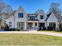 Charming two-story home boasts a bright white painted brick exterior and a well-manicured lawn at 500 Chillingworth Ln, Charlotte, NC 28211