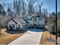 Charming two-story home featuring a spacious driveway, attached garage, and landscaped front yard on a sunny day at 5050 Watersail Way, Lake Wylie, SC 29710