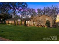 Beautiful brick home featuring a lush green lawn and mature landscaping at 6621 Fair Lawn Rd, Charlotte, NC 28215