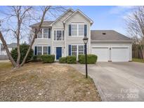 Charming two-story home featuring blue shutters, a well-manicured lawn, and a two-car garage at 9413 Pastern Ct, Charlotte, NC 28216
