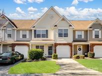 Charming townhome featuring a well-manicured lawn, a one-car garage, and a classic brick facade at 11420 Glaetzer Ln, Charlotte, NC 28270