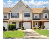 Charming townhome featuring a well-manicured lawn, attached garages, and a welcoming facade at 11420 Glaetzer Ln, Charlotte, NC 28270