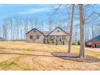 Charming brick home featuring a welcoming front porch and well-maintained landscaping on a sunny day at 1509 Avalon Oaks Ct, Dallas, NC 28034