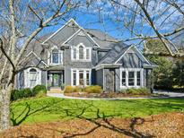 Charming two-story gray home with a manicured lawn and beautiful landscaping at 19000 Hodestone Mews Ct, Davidson, NC 28036